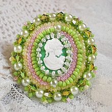 Bague Anisse brod&eacute;e d&rsquo;un cabochon r&eacute;sine repr&eacute;sentant une femme et des roses, orn&eacute;e de rocailles Vert Anis, Rose, Jaune Nacr&eacute; et Ivoire. Elle est finie avec des toupies et perles sur bague r&eacute;glable 